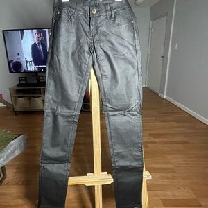 Black wax low-rise skinny pants with gold accents